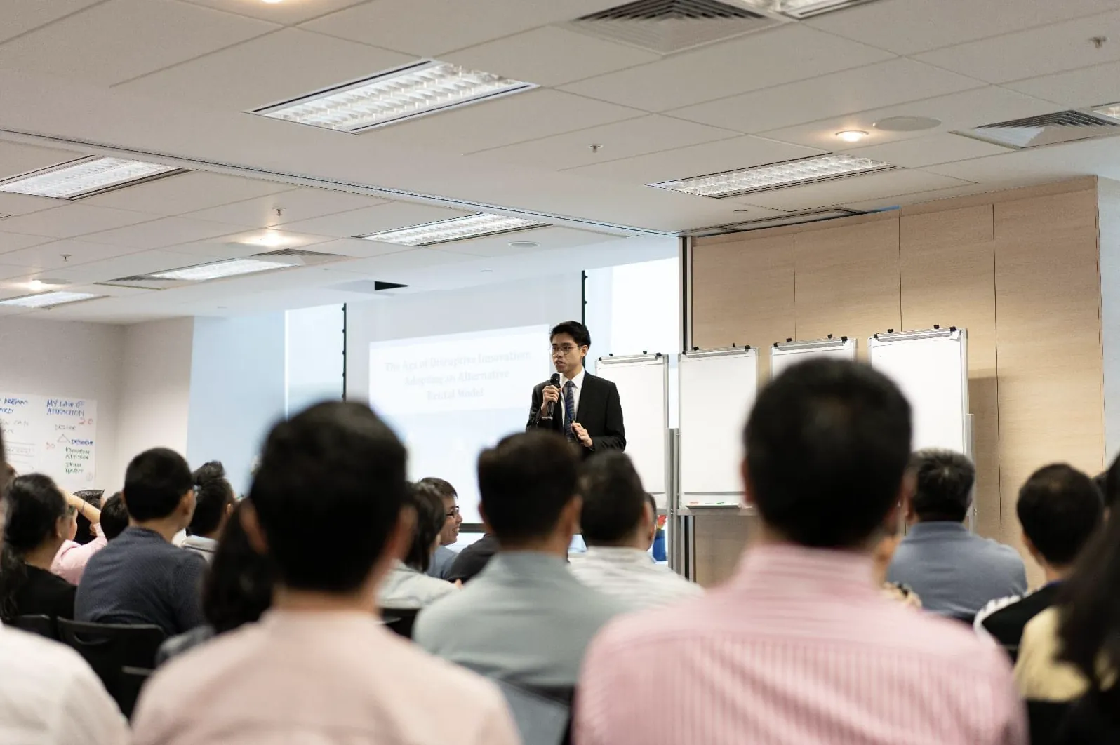Tom Chang Thawat presenting on stage to an audience