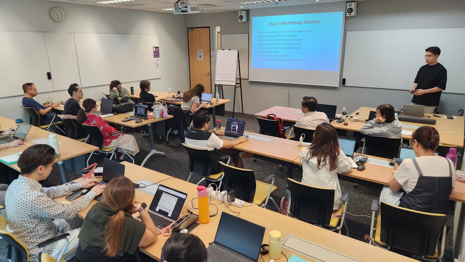 Tom Chang Thawat leading a live AI content creation workshop, class working on laptops